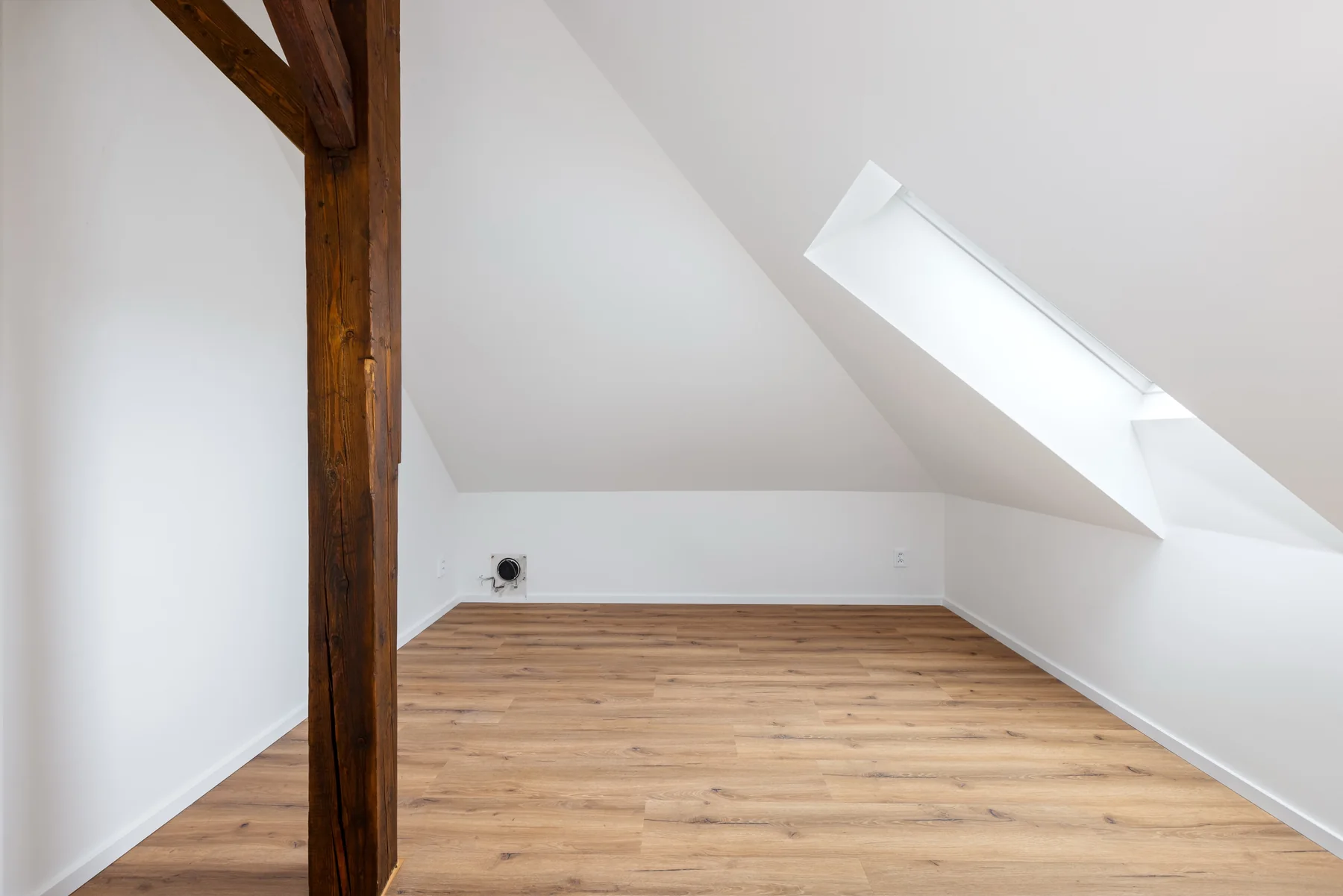 Byt 7 – podkrovní pokoj se střešním oknem a dřevěným trámem / Apartment 7 – attic room with a skylight and timber beam
